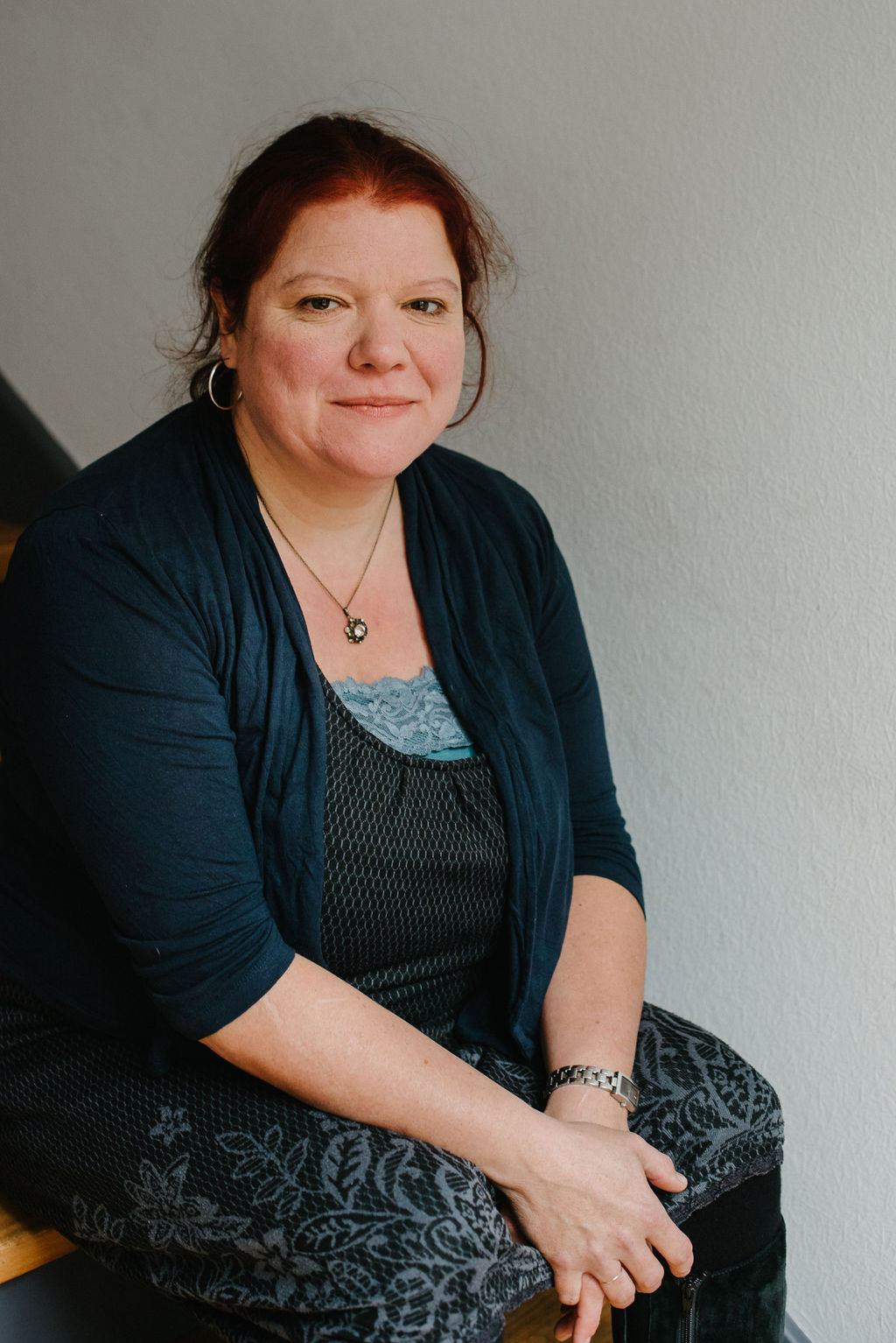 Natalie sitzt auf einer Treppe und schaut ruhig in die Kamera