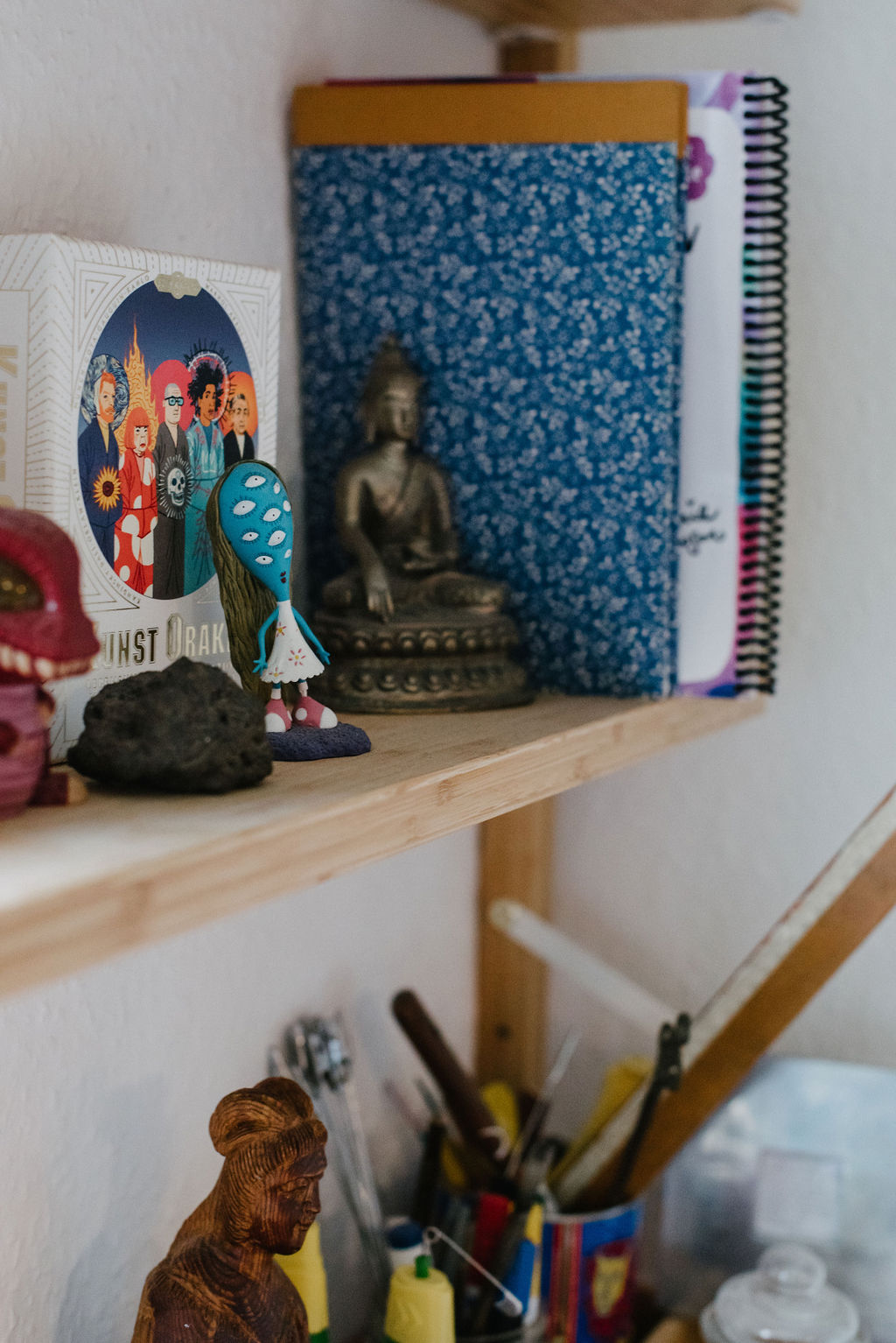 Ein Regalbrett mit verschiedenen dekorativen Figuren und Büchern